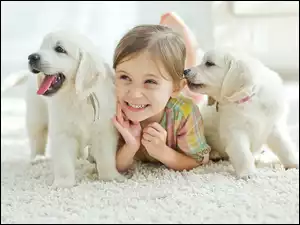 Radosna dziewczynka z dwoma słodkimi szczeniakami