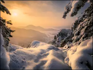 Zamglony zachód słońca w zimowych górach