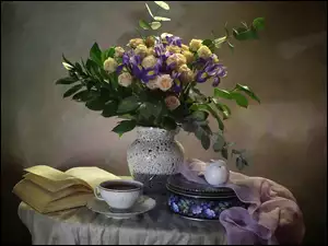 Kwiatowy bukiet obok książki i herbaty