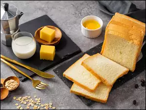 Kromki chleba tostowego obok szklanki mleka i sera żółtego