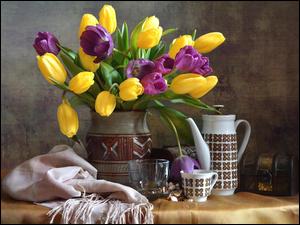 Żółte i fioletowe tulipany w wazonie obok dzbanka i filiżanki