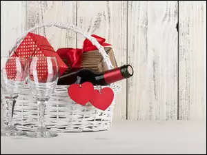 Kosz z winem i prezentami razem z czerwonymi serduszkami