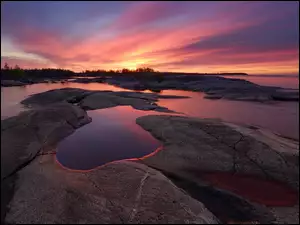 Skały i wysepki na jeziorze Ładoga o zachodzie słońca