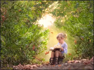 Dziewczynka z książką w ogrodzie