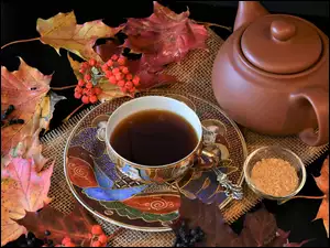 Ozdobna filiżanka z herbatą i czajnik w jesiennej kompozycji