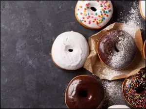Donuty w posypce na ciemnym tle