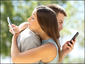 Przytulanie mężczyznę i kobietę ze smartfonów