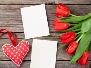 Kartki obok serca i tulipanów na deskach