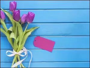 Bukiet fioletowych tulipanów na niebieskich deskach