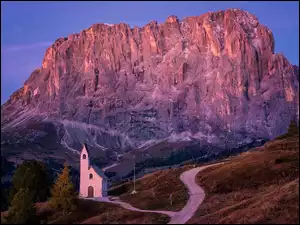 Droga i kościół św. Jana na tle masywu skalnego w Dolomitach