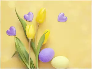 Pisanki i serduszkami obok żółte tulipany
