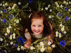 Uśmiechnięta dziewczynka z letnimi kwiatkami