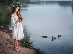 Uśmiechnięta dziewczyna w wianku nad rzeką