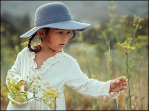 Dziewczyna z kapelusza odbiera kwiaty na łące