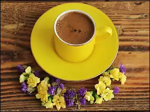 Kompozycja z filiżanką kawy i kwiatami na desce