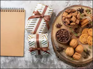 Notes i prezenty obok orzechów ciasteczek na desce