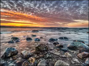 Zachód słońca nad kamieniami morskimi