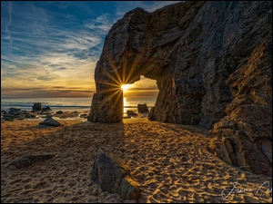 Promienie słońca w łuku skalnym Arche de Port Blanc na wybrzeżu Bretanii