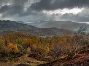 Ciemne chmury nad górami i lasami jesienią
