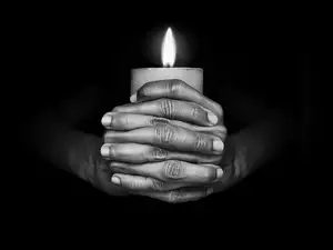 Paląca świeczka w dłoniach