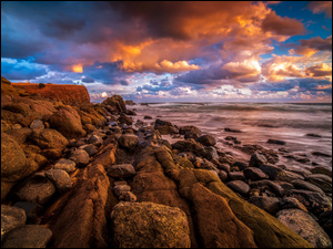 Kamienie i głazy nad brzegiem morza pod zachmurzonym niebem