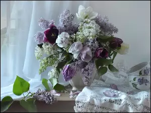 Bukiet z kwiatów bzu i tulipanów na stole