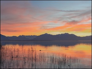 Zachód słońca nad jeziorem i górami