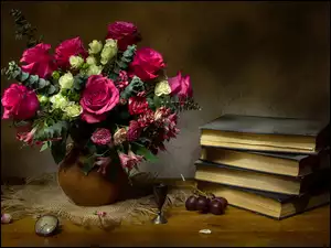 Bukiet róż w wazonie obok książek na stole