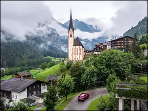 Kościół w austriackimmiasteczku Heiligenblut na tle zamglonych Alp