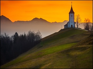 Kościół św Primusa i Felicjana w Słowenii pod pomarańczowym niebem