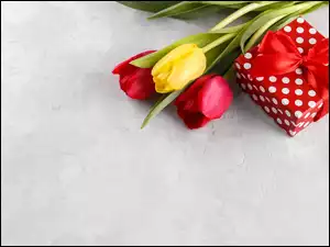 Prezent obok trzech tulipanów