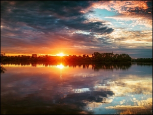 Chmury i zachód słońca nad jeziorem