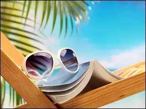 Leżak z książką i okularami pod palmą