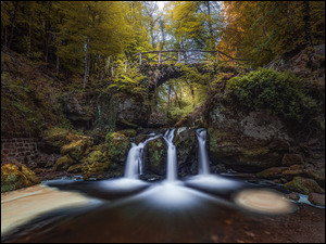 Most i wodospad na sklale w jesiennym lesie