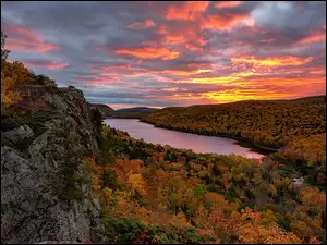 Widok ze skał na zachód słońca nad jesiennymi lasami nad rzeką