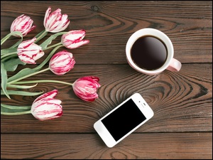 Tulipany z kawą i telefonem na deskach