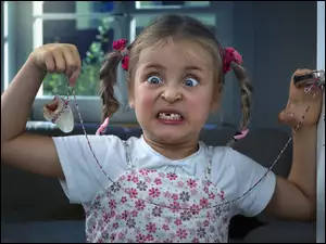 Dziewczynka trzymająca wyrwanego zęba na sznurku