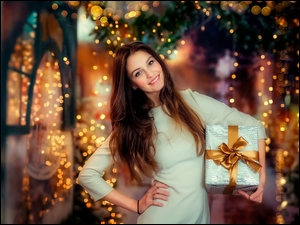 Uśmiechnięta kobieta z prezentem gwiazdkowym w świątecznym nastroju