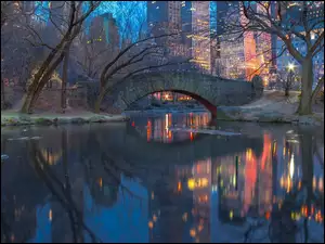 Most nad rzeką w oświetlonym nowojorskim Central Parku na Manhattanie