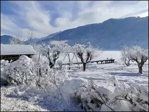 krajobraz zimowy z górami i śnieżną chatą