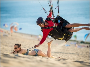 Dziewczyna na plaży i spadochroniarz