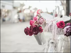 Rower z białym koszykiem i różami
