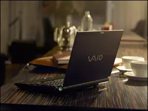 Laptop Marki VAIO na stole z filiżankami