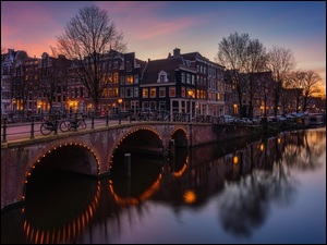 OĹwietlone domy nad kanaĹem Leidsegracht w Amsterdamie