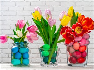 Kolorowe tulipany i jajka w naczyniach szklanych