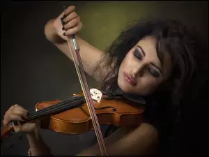 Grająca na skrzypcach ciemnowłosa kobieta