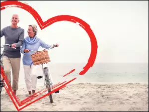Para z rowerami na plaży w sercu