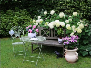Romantyczne miejsce w ogrodzie z kwiatami i meblami