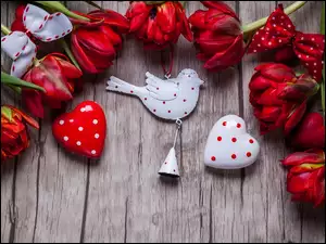 Walentynkowa kompozycja z czerwonych tulipanów serduszek i ptaszka