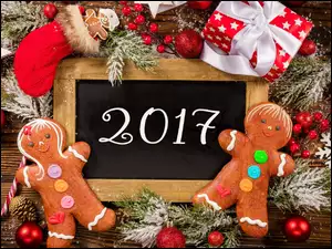 Piernikowe ludziki w dekoracji obok napisu obszeszczającego Nowy 2017 rok